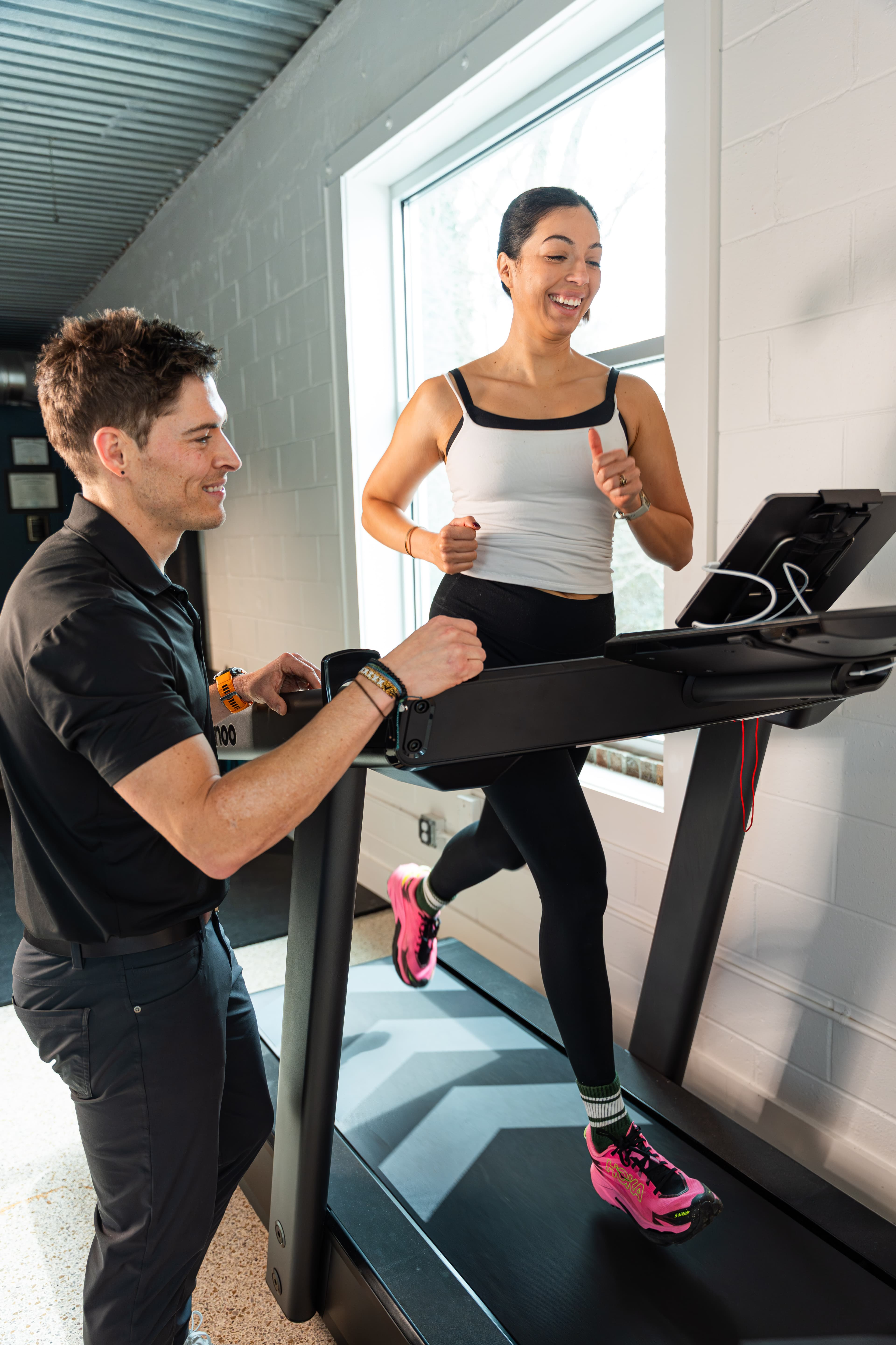 Physical therapist conducting a running gait analysis while a patient runs on a treadmill at Swamp Rabbit Physiotherapy in Greenville, SC