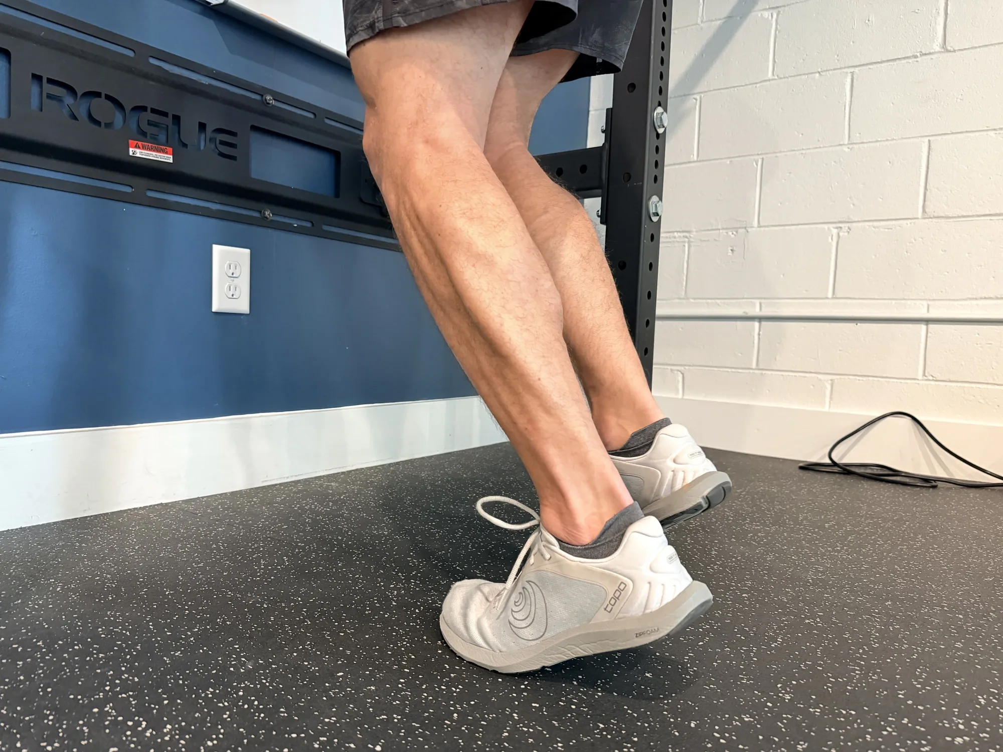 Close-up of a runner’s calves and heels at the top of a calf raise, showing the calf-Achilles muscle-tendon unit under load at Swamp Rabbit Physiotherapy in Greenville, SC